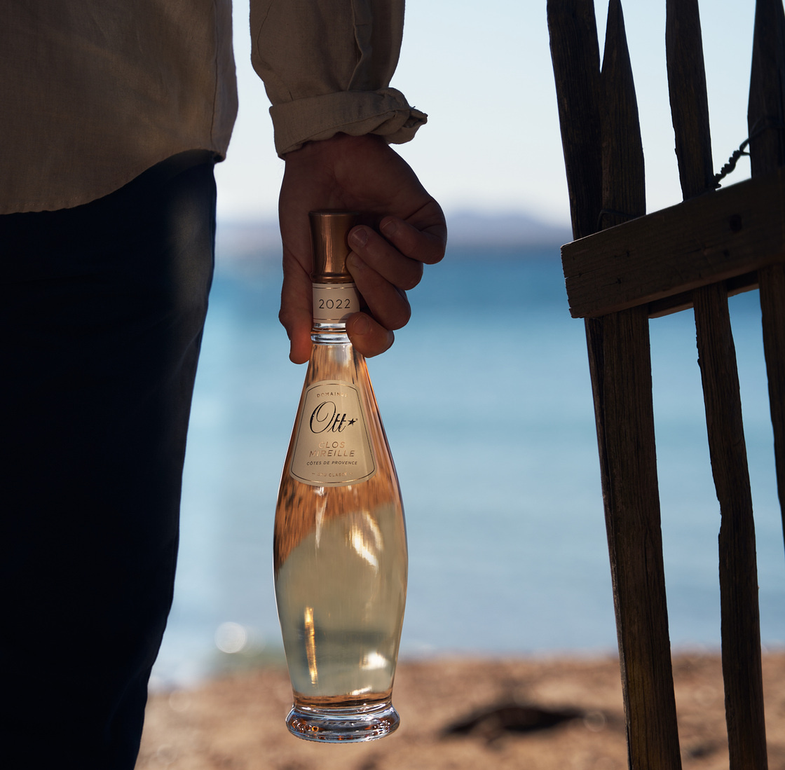 clos-mireille-rose-tenue-par-une-main-a-la-plage
