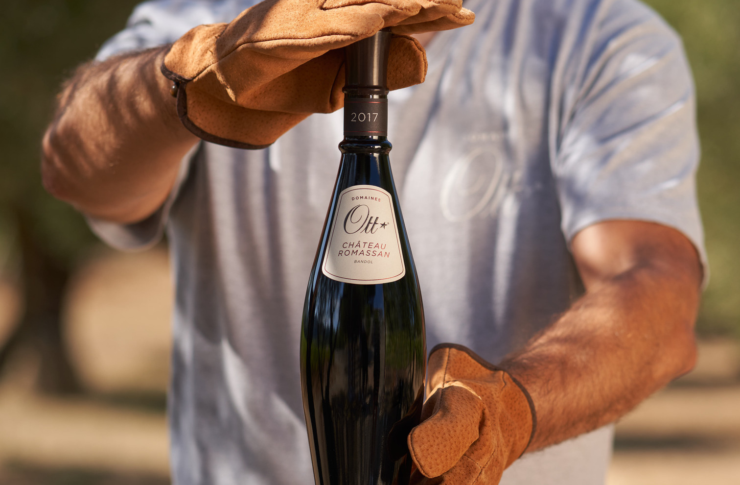 un-vigneron-tenant-fierement-une-bouteille-domaines-ott